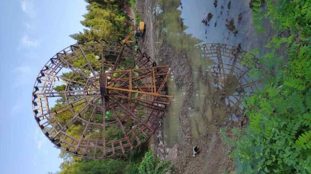 湖北天门小南湖公园大型仿古水车深色施工中河边房屋_大型仿古水车定制厂家_大型仿古水车深色施工中河边房屋传统木作工人脚手架水流树木